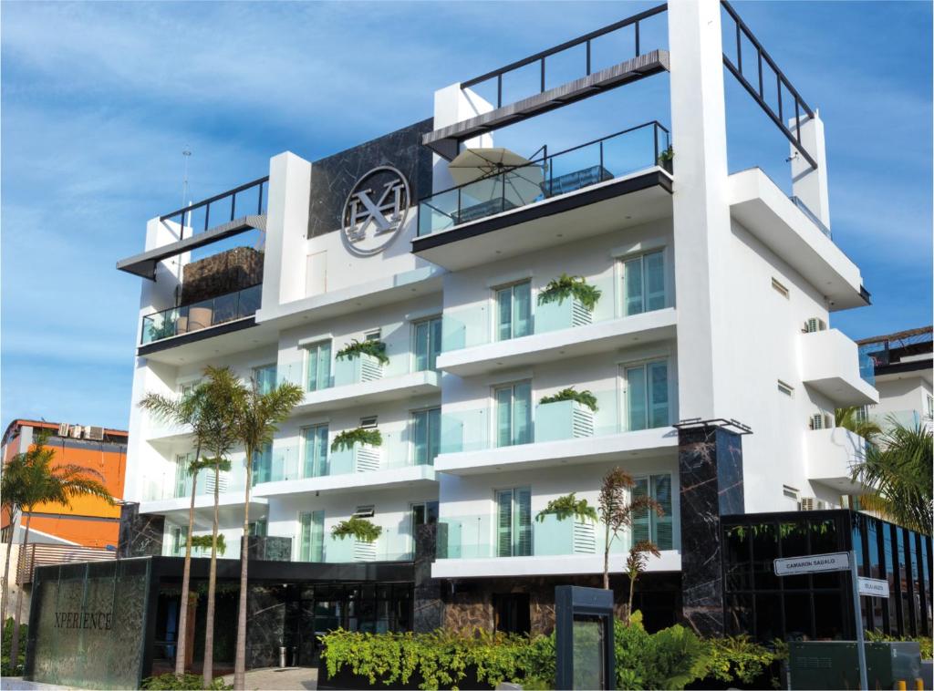a white building with a clock on it at The Xperience by g - Adults only in Mazatlán