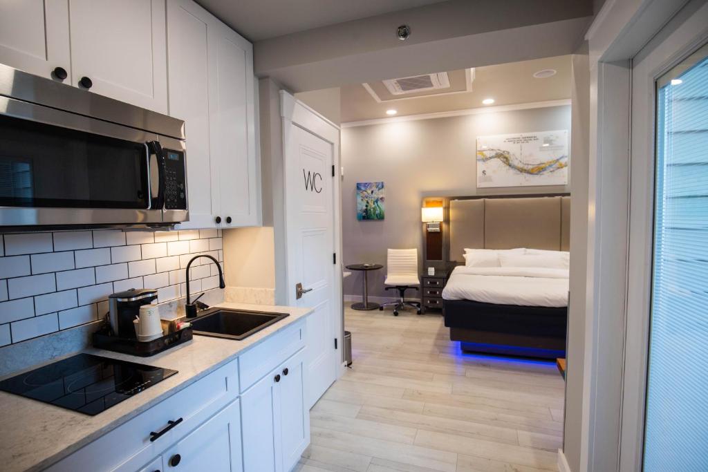 a kitchen with a sink and a bed in a room at River Sirens Hotel-Contactless Check in Hotel in Washington