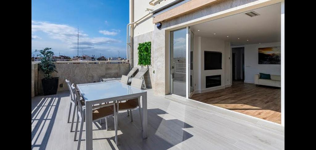 eine Terrasse mit einem Tisch und Stühlen auf dem Balkon in der Unterkunft Atico de Lujo in Valencia