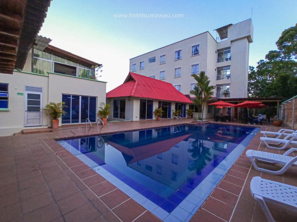 a swimming pool in front of a building at Hotel Suma Wasi in Mocoa