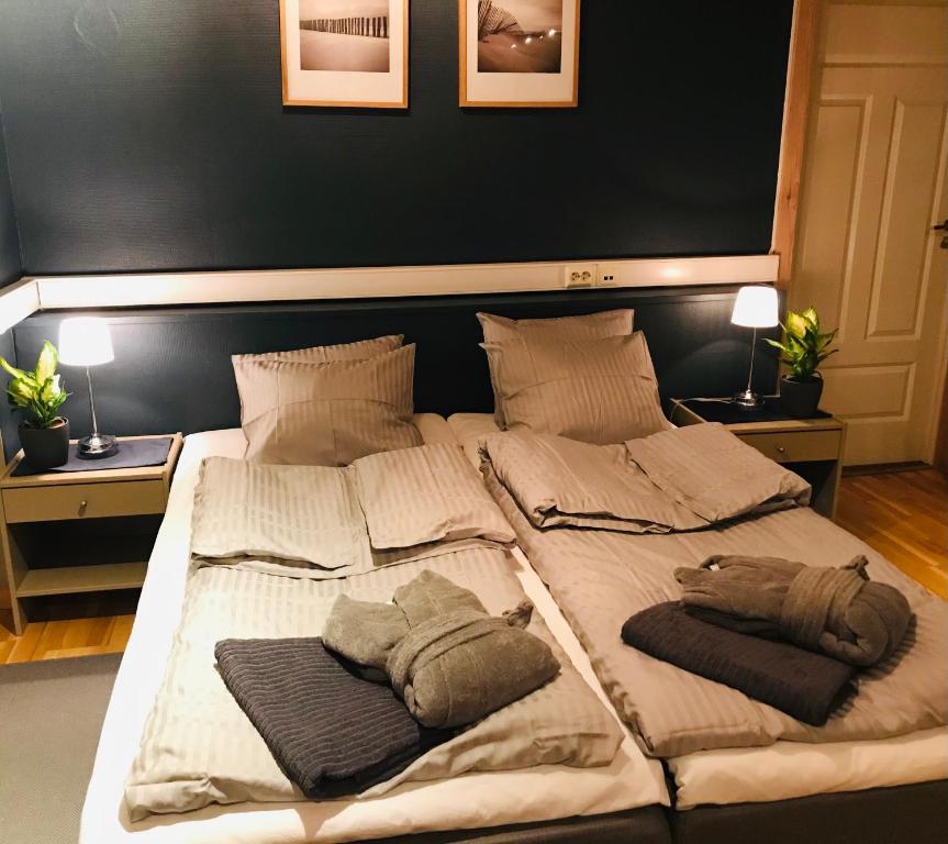 a large bed with two pillows on top of it at Taras Rom og leiligheter in Kragerø