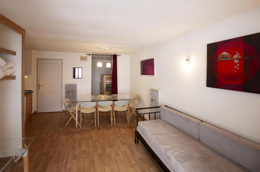 sala de estar con sofá y mesa en Chalets de Florence FORET & FAMILLE appartements by AlpVision Résidences, en Valfréjus