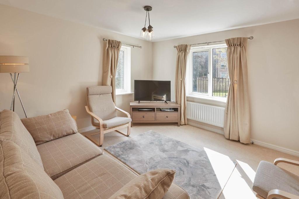 a living room with a couch and a tv at Host & Stay - 57 Woodland View in Holmfirth