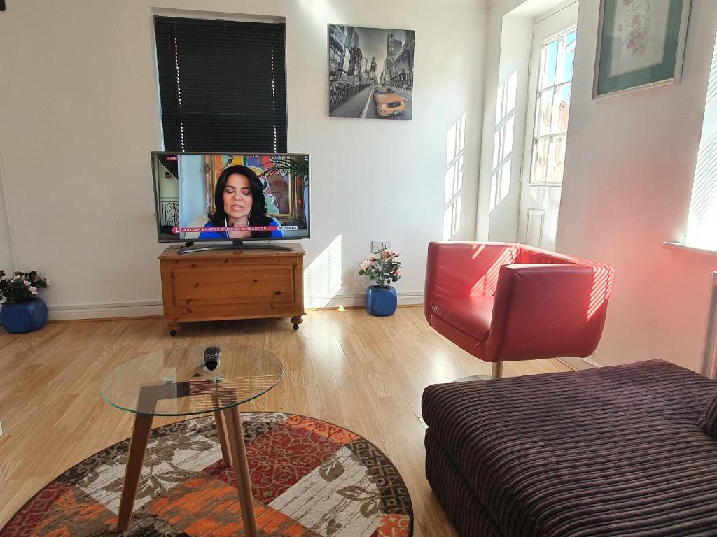 ein Wohnzimmer mit einem Flachbild-TV auf einer Kommode in der Unterkunft Mannys Apartment - Nice & Cozy 4Bed Flagship Lodge in Sittingbourne