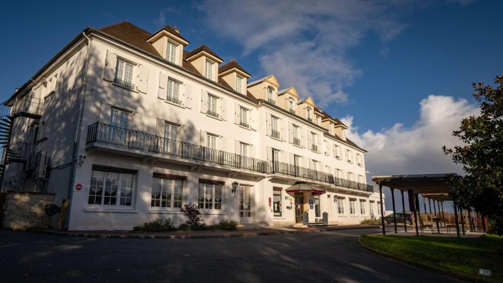 een wit gebouw met een balkon in een straat bij Best Western Hotel Ile de France in Château-Thierry