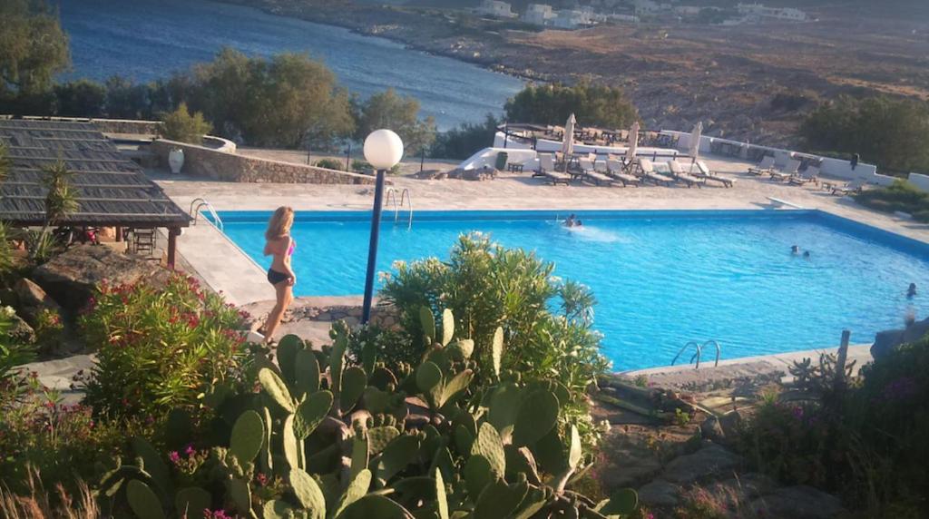 una mujer está de pie junto a una piscina en Afrodite Villa on the Sea, en Ornos