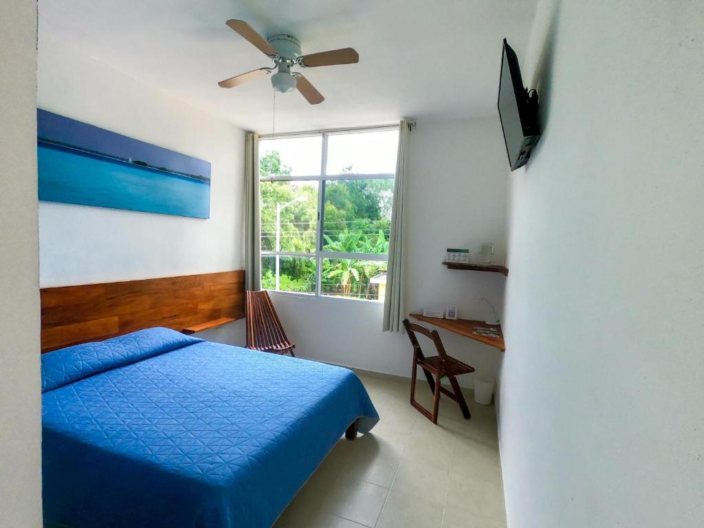 ein Schlafzimmer mit einem blauen Bett und einem Fenster in der Unterkunft Gran Jaguar Hotel in Bacalar