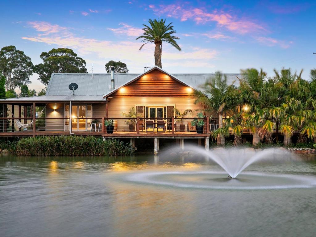 a house with a fountain in the water in front of it at Lilies on Lovedale Estate - Heated Pool and Spa in Lovedale