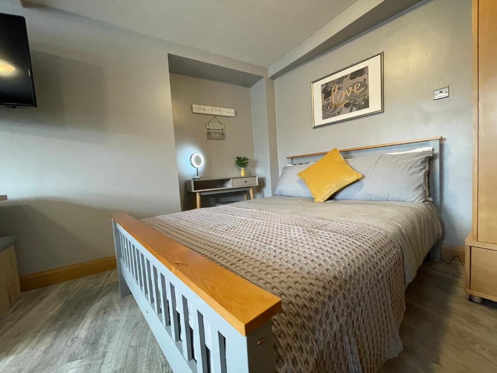 Un dormitorio con una cama grande con una almohada amarilla. en Westend Holiday Let 1 Brecon, en Brecon
