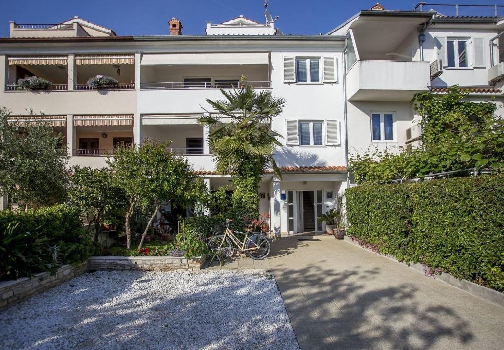 ein weißes Gebäude mit einem Fahrrad davor in der Unterkunft Apartments Marija - 500 m from beach in Rovinj