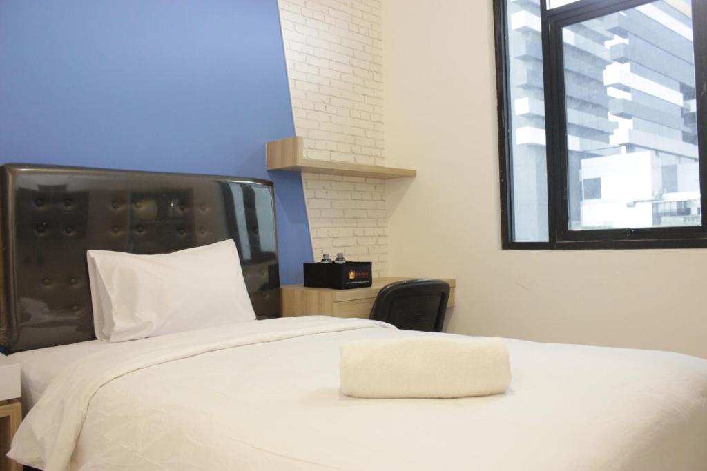 バンドンにあるPleasant Studio Semi Apartment at The Lodge Paskal near BINUS University By Travelioの白いベッド(上に白い枕付)