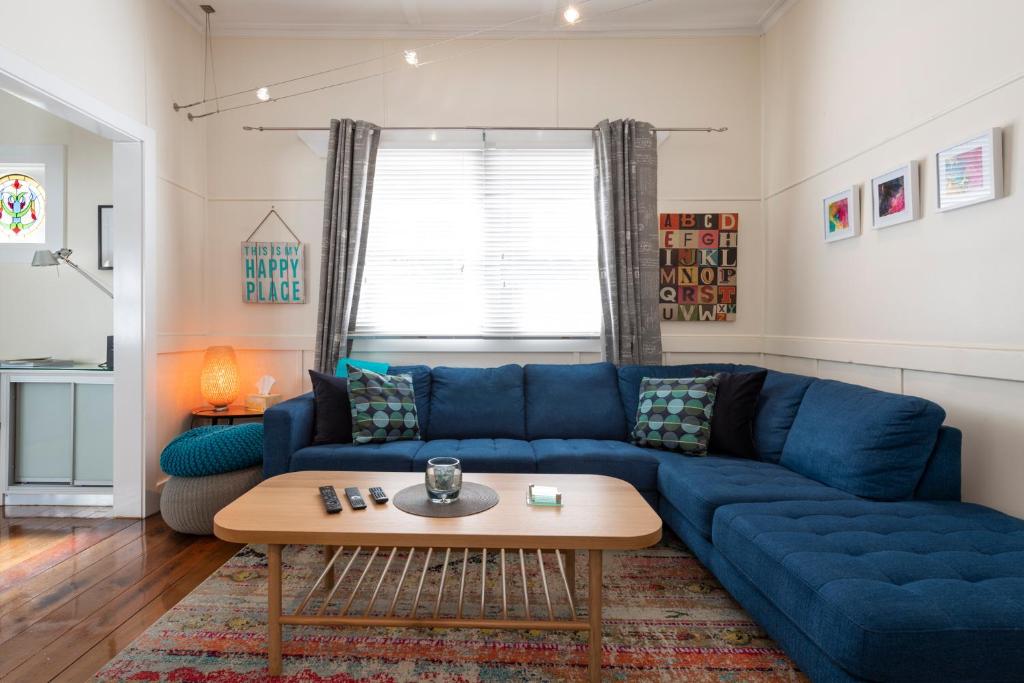 a living room with a blue couch and a table at Blackheath Nook in Blackheath