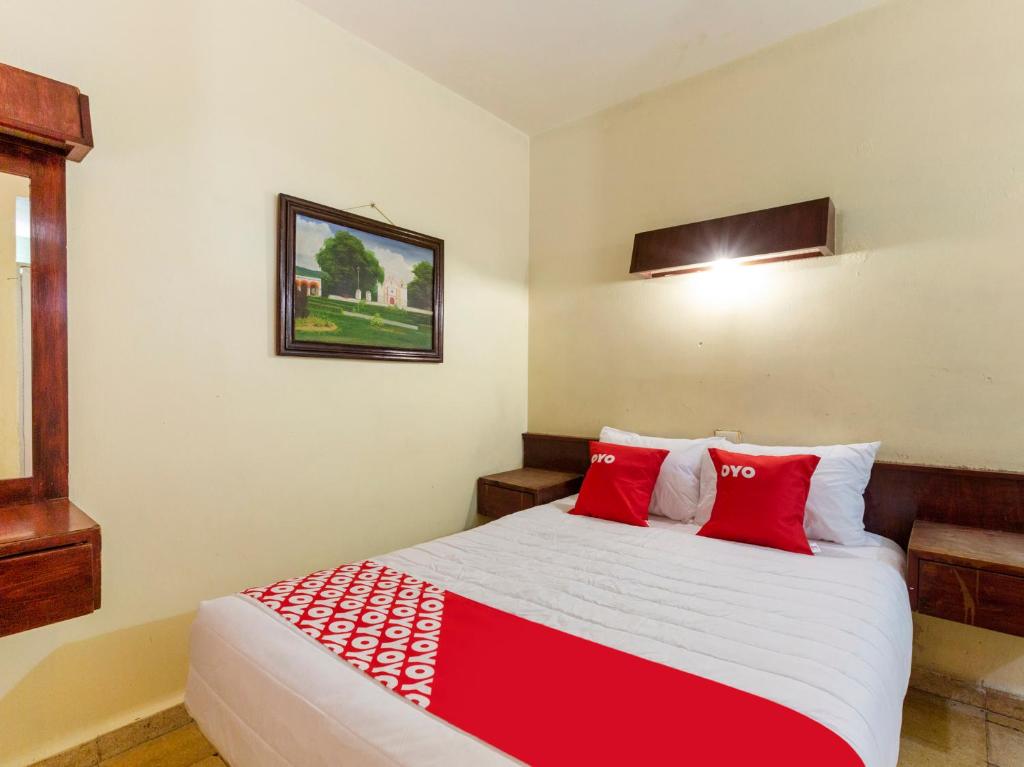 a bedroom with a large bed with red pillows at OYO Hotel Emperador, Oaxaca in Oaxaca City