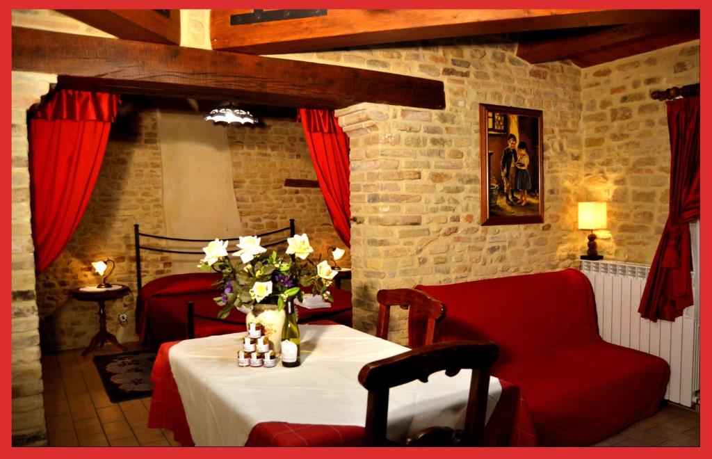 una habitación con una mesa con una silla roja y flores en Al Castello di Montalfoglio en San Lorenzo in Campo