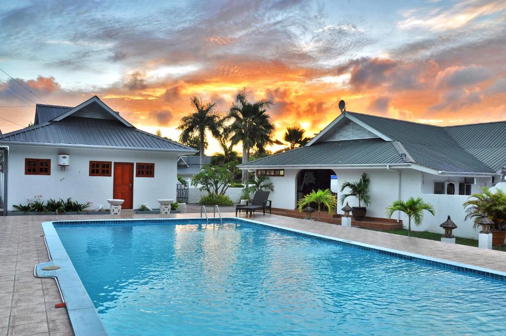 una villa con piscina di fronte a una casa di Britannia Hotel a Grand'Anse Praslin