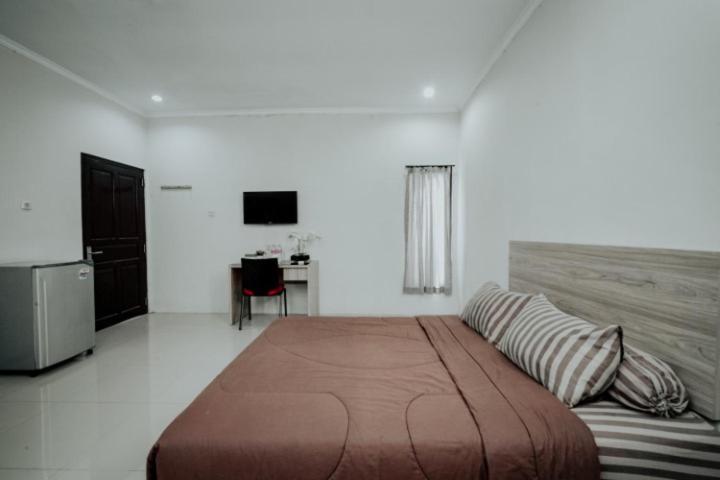 sypialnia z dużym łóżkiem i telewizorem w obiekcie DPARAGON MT HARYONO w mieście Semarang