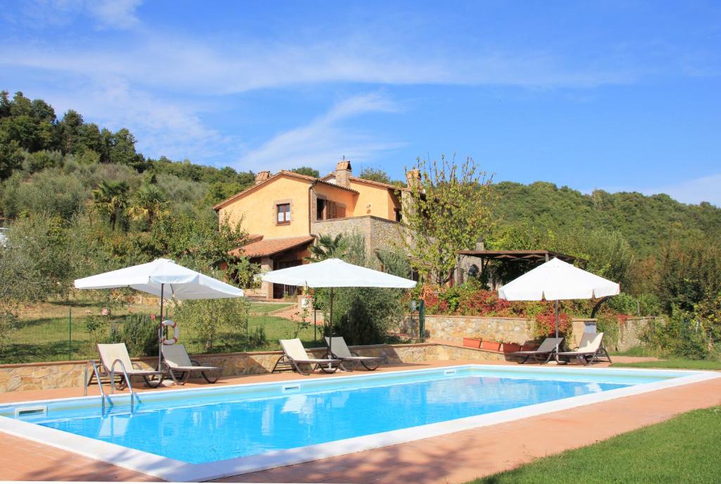 a swimming pool with chairs and umbrellas and a house at Agriturismo Parzalla in Ficulle