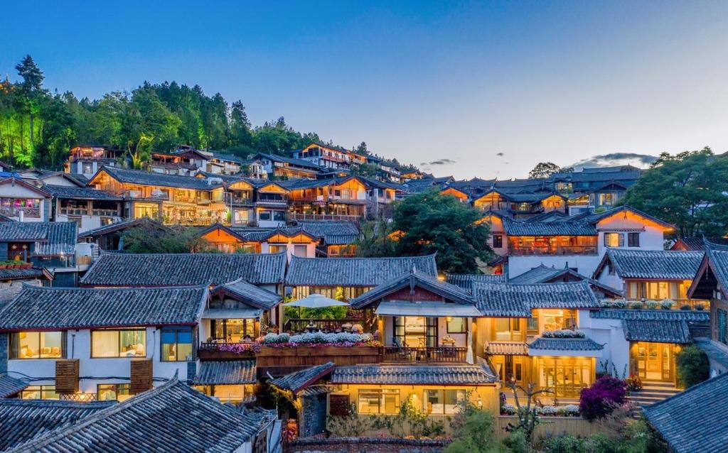 Lijiang Sunshine Nali Inn في ليجيانغ: مجموعة كبيرة من المنازل في قرية في الليل