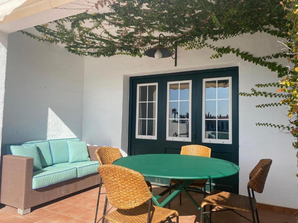 un patio con mesa, sillas y sofá en ATALAIA 5 by SOM Menorca, en Fornells