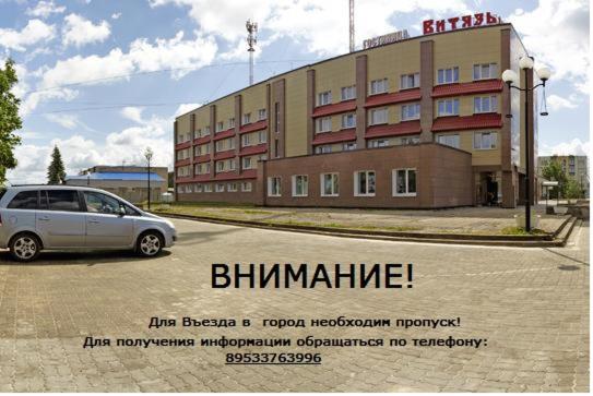 un coche aparcado en un aparcamiento frente a un edificio en Hotel Vityaz, en Ivángorod