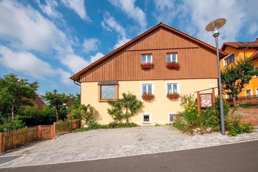 una casa con fiori alle finestre e una recinzione di Ferienwohnungen Am Sonnenhang a Theisseil