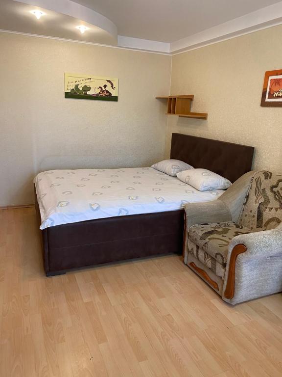 a bedroom with a large bed and a couch at Studio on Vandy Vasylevskoi 8 in Kyiv
