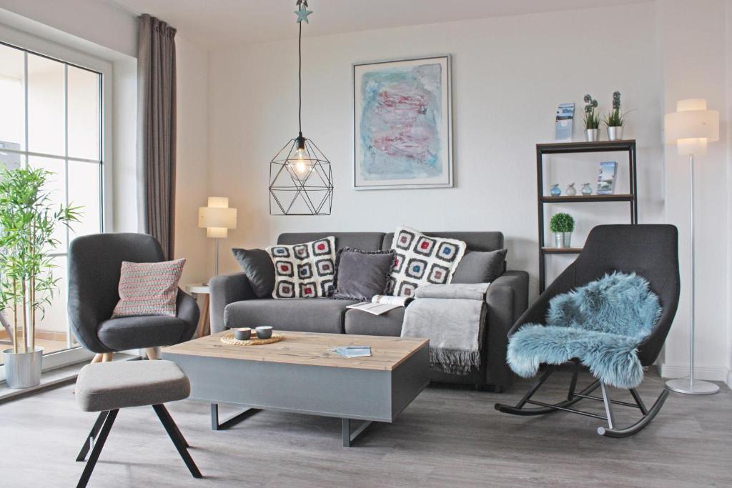 sala de estar con sofá y 2 sillas en fewo1846 - Strandresidenz Wassersleben KuestenNest - luxuriöses Studioapartment mit Balkon und Meerblick, en Harrislee