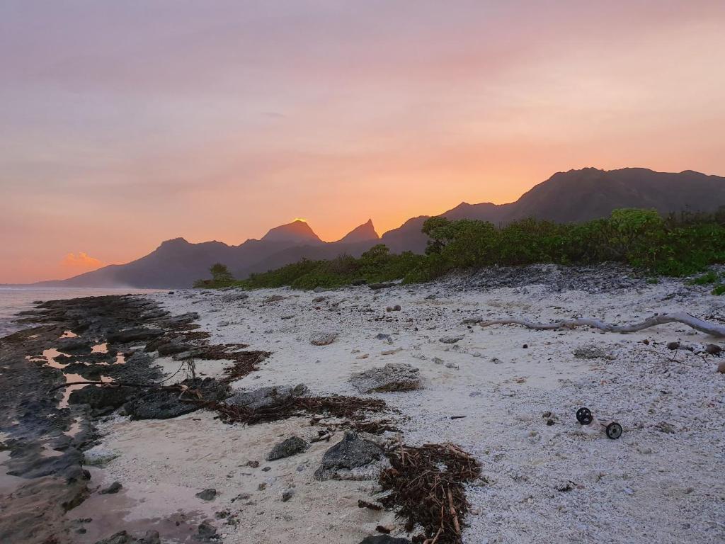 a beach with mountains in the background and the ocean at Moorea Lodge in Temae