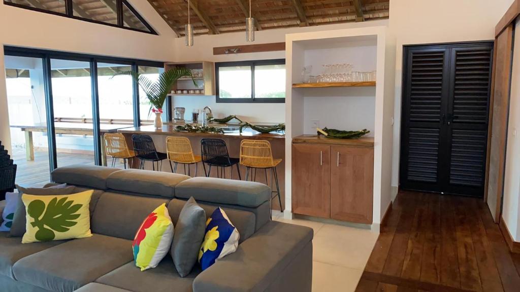 a living room with a couch and a kitchen at Moorea Lodge in Temae