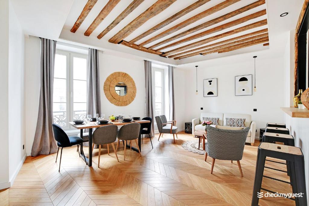 un salon avec une table et des chaises dans l'établissement CMG Résidence République II - Rue Béranger, à Paris