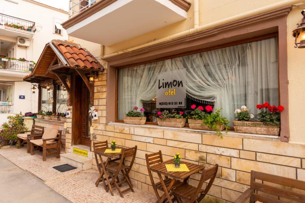 LİMON OTEL FOÇA في فوكا: مطعم فيه طاولات وكراسي امام شباك
