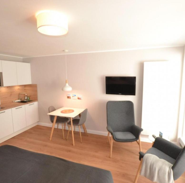 sala de estar con mesa y 2 sillas en Appartement-5-Kurviertel, en Westerland