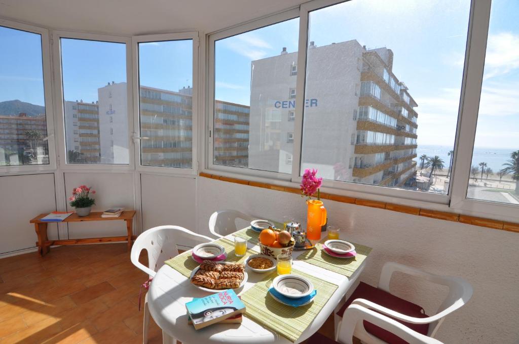 uma mesa com comida numa sala com janelas em RNET - Playa Sol - Roses Costa Brava em Santa Margarita