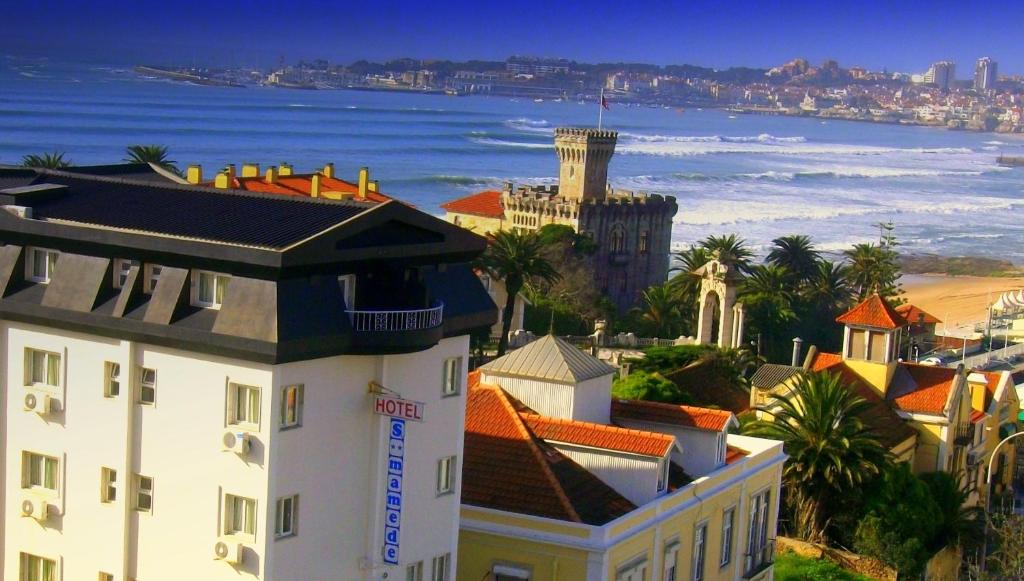 uitzicht op een stad met de oceaan en gebouwen bij Hotel Sao Mamede in Estoril