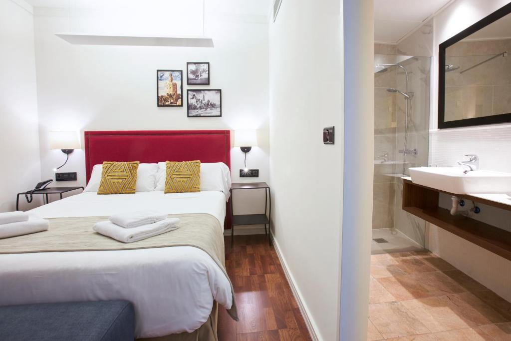 Postel nebo postele na pokoji v ubytování U-Sense Sevilla Centro