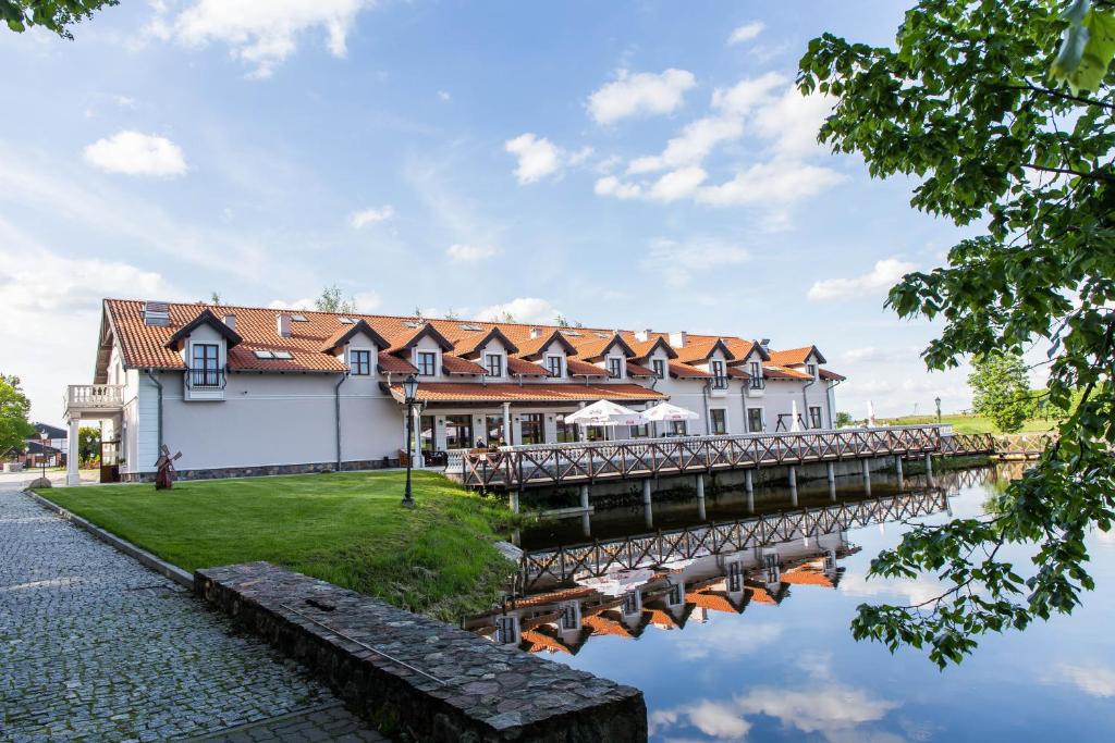 een gebouw met een brug naast een waterlichaam bij Palac Mortegi Hotel & SPA - W FERIE ZIMOWE DWOJKA DZIECI DO LAT 12 W CENIE POBYTU!!! in Lubawa