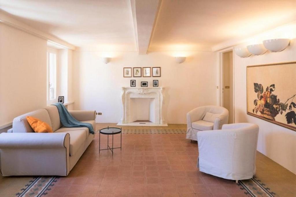 een woonkamer met een bank en stoelen en een open haard bij Mario's apartament with AC and wifi in Lucca