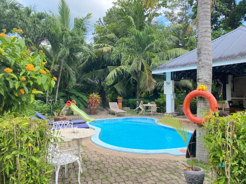 ein Pool mit Rutsche neben einem Haus in der Unterkunft Chalets de Palma in La Digue