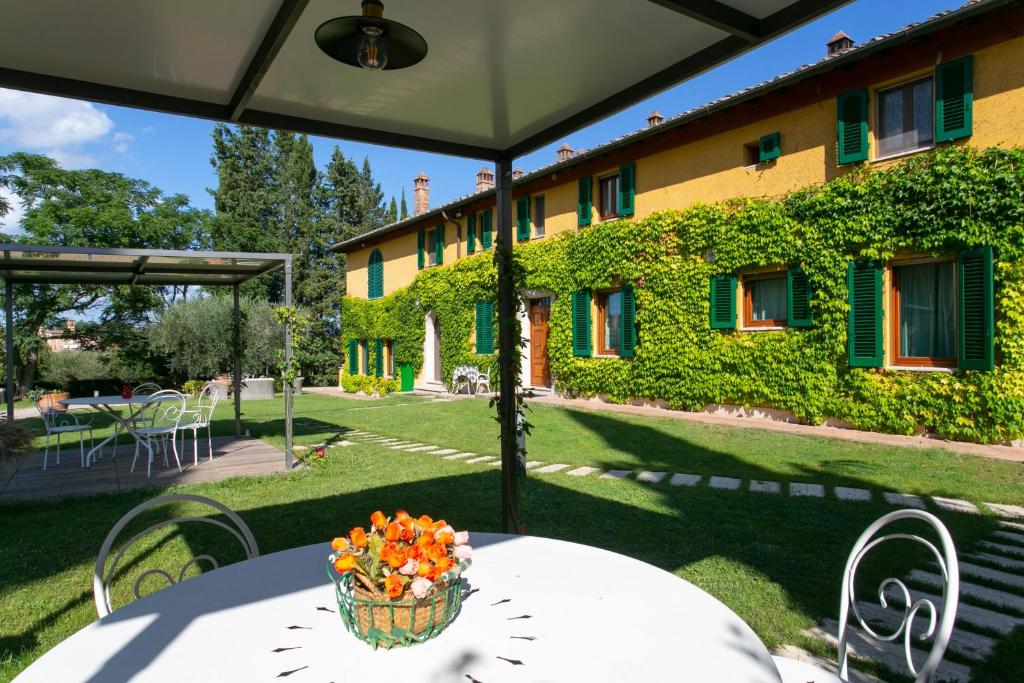 ein weißer Tisch mit einem Korb mit Blumen drauf in der Unterkunft Villa Santa Chiara in Siena