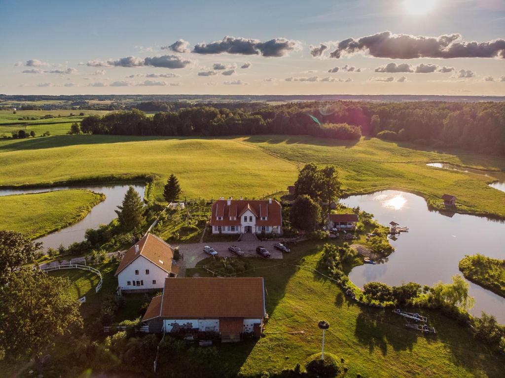 uma vista aérea de uma quinta com uma casa e um lago em Farm & Country House Gizewo 32 em Sorkwity