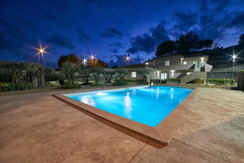 a large blue swimming pool in front of a house at Il Casale di Monacella in Santa Venerina
