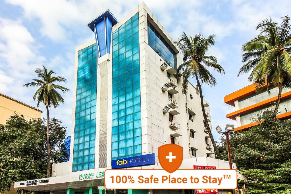 a tall building with a sign in front of it at FabHotel Sahar Garden Marol in Mumbai