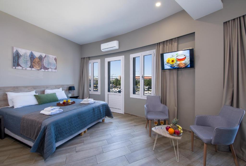 a bedroom with a bed and a flat screen tv at Stoa Suites Chania in Chania