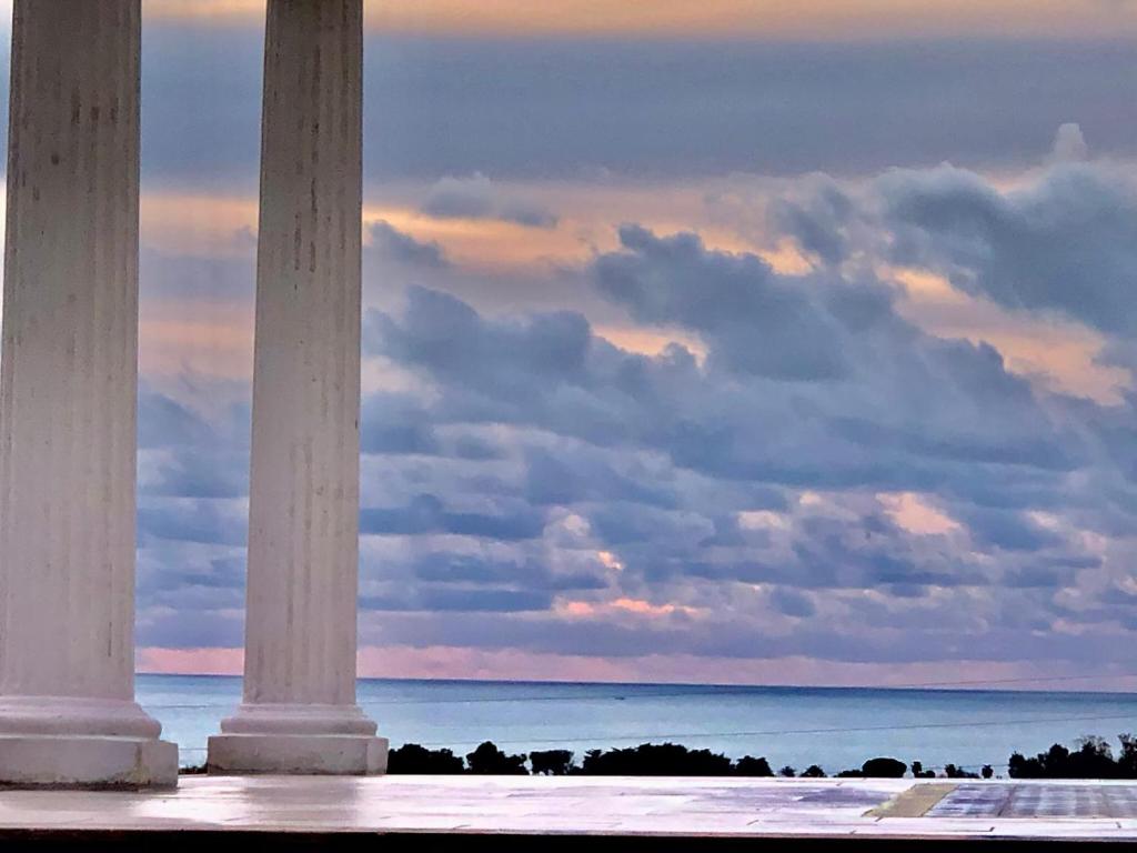 a view of the ocean from the columns of a building at L'incanto di Nausicaa in Ascea