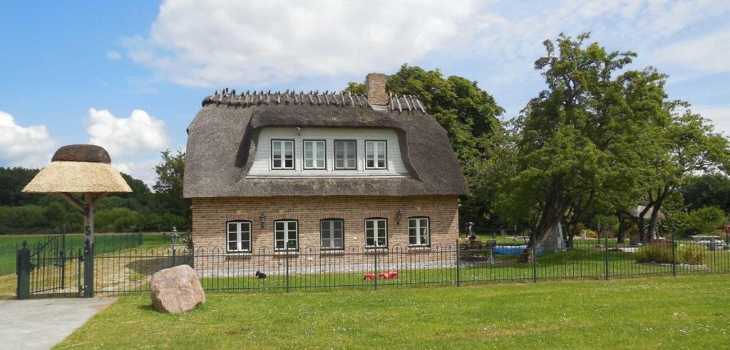 a small house with a roof in a field at Landhausvilla Wolsroi in Steinbergkirche