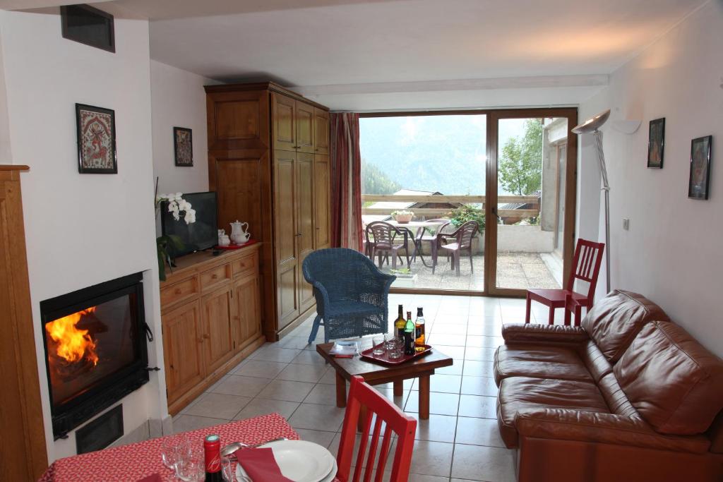 een woonkamer met een bank en een open haard bij Chalet Bouquetin- Loir in Champagny-en-Vanoise