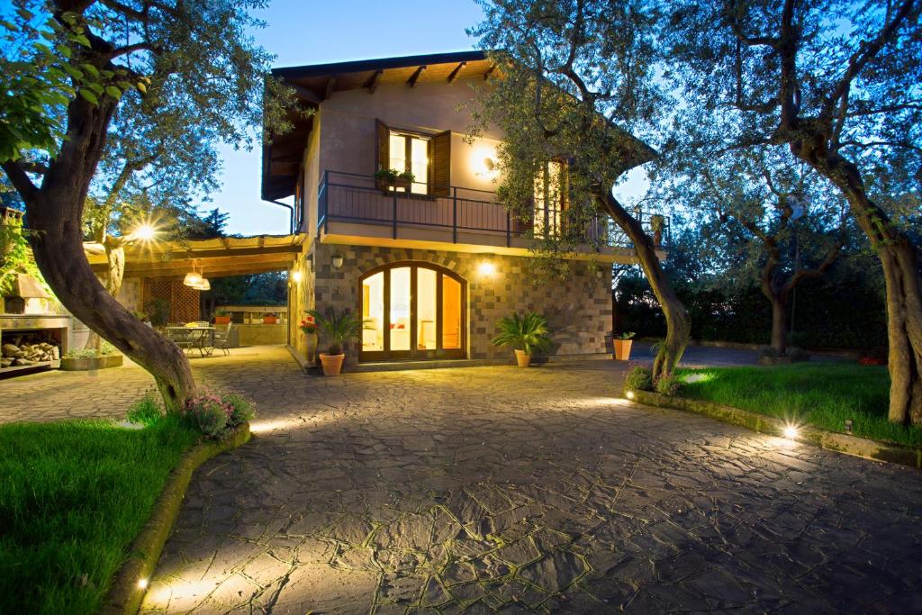 una casa con entrada de piedra y árboles por la noche en Villa Regina Giovanna, en Sorrento