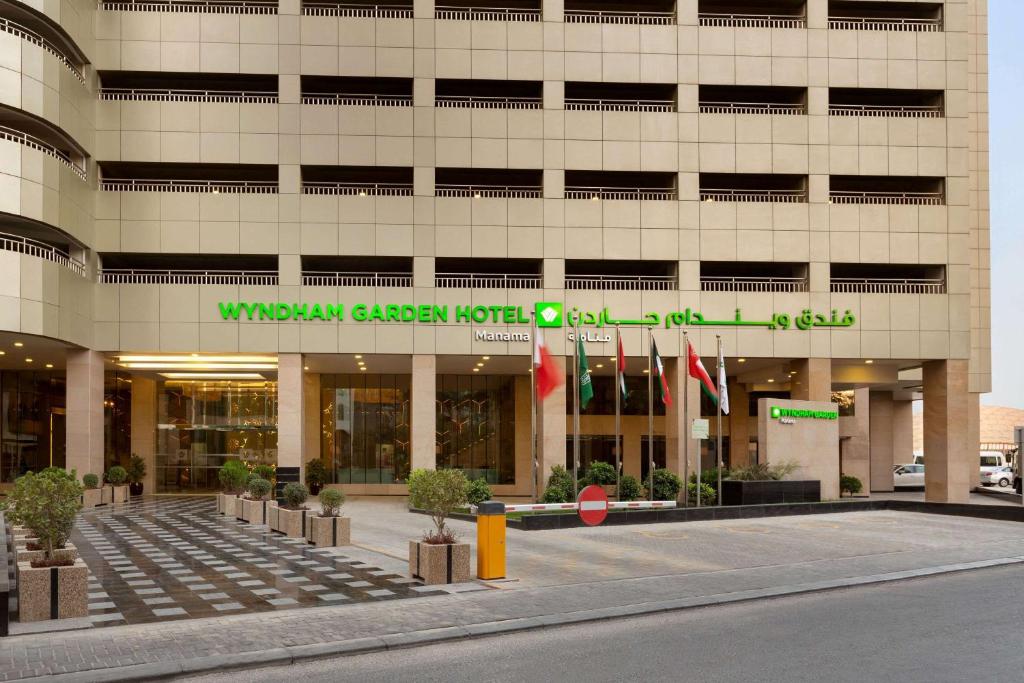 a building with a sign on the front of it at Wyndham Garden Manama in Manama