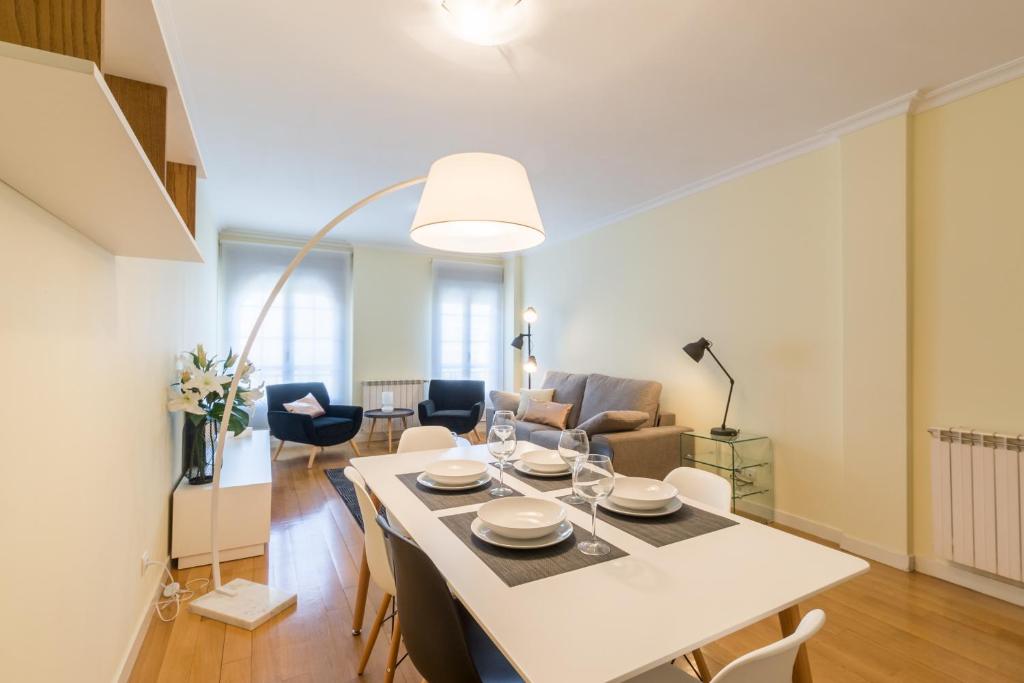 comedor y sala de estar con mesa blanca y sillas en MIT House Retiro II en Madrid Capital, en Madrid