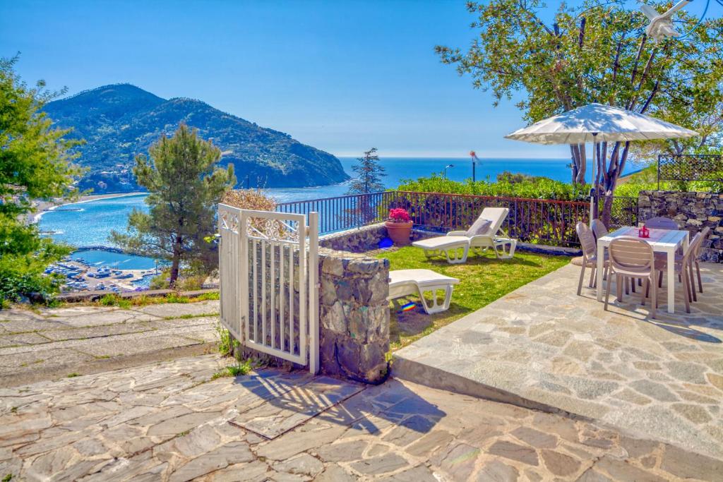 patio con ombrellone, tavolo e sedie di MARLA House Sea View a Levanto